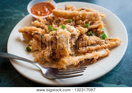 Plate of crispy calamari rings appetizer on green marble table