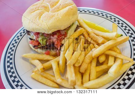 Cheeseburger on a kaiser roll with steak fries on the side