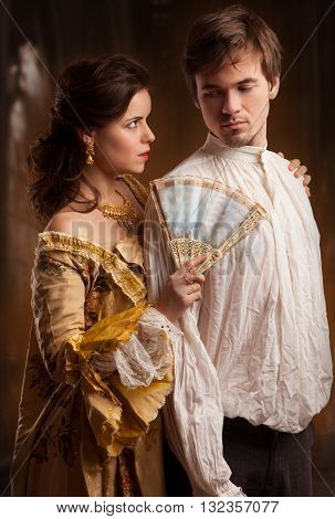 Lover couple. Man and woman standing on a stone wall background. Love relationship in a pair of man and woman. Images of the novel about love. Woman dreams. Man's instinct. Passionate, kissing, hugs.
