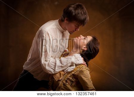 Lover couple. Man and woman standing on a stone wall background. Love relationship in a pair of man and woman. Images of the novel about love. Woman dreams. Man's instinct. Passionate, kissing, hugs.