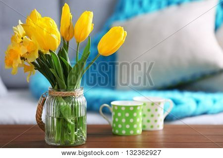 Yellow spring flowers in living room interior