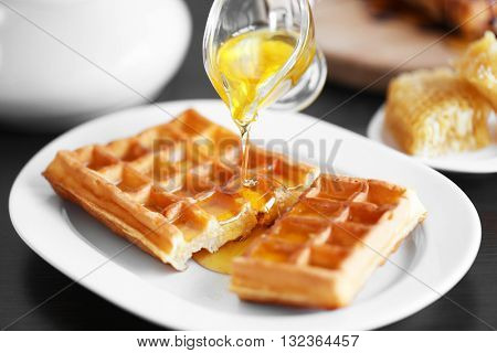 Pouring honey on waffles
