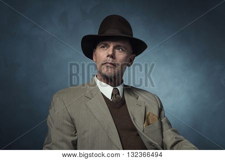 Fashionable Retro 1940 Business Man With Hat Against Gray Wall.