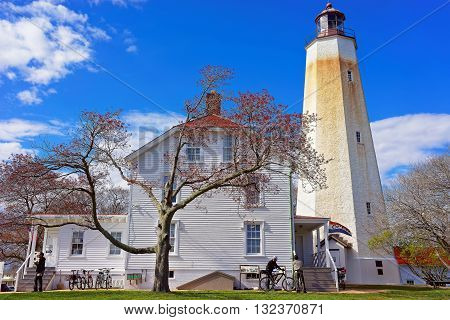 Middletown Township USA - April 26 2015: Sandy Hook Light tower and house building. Sandy Hook is located in Highlands in Monmouth County of New Jersey USA. Tourists nearby
