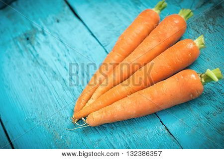 Carrot on the old blue wooden boards. Bright carrots. Toned image. Selective focus.