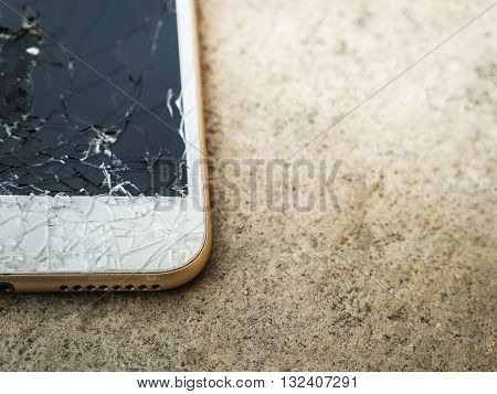 Close up of broken mobile phone or tablet droped on cement floor with copy space High contrast