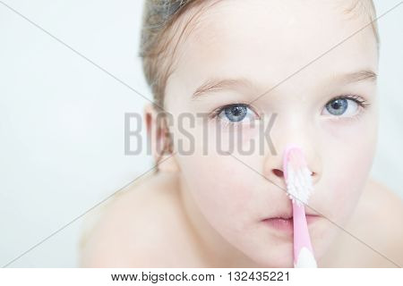 Dental hygiene. Close up of little girl brushing her teeth. Fun in the bath