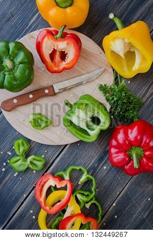 Assorted colorful varieties of sweet peppers sitting on old wooden table rustic style selective focus