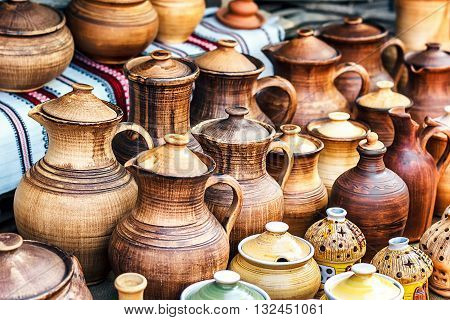 Group of traditional handmade pottery for sale at the market. Ukrainian handmade earthenware utensil. Souvenirs From Ukraine in ethnic style.
