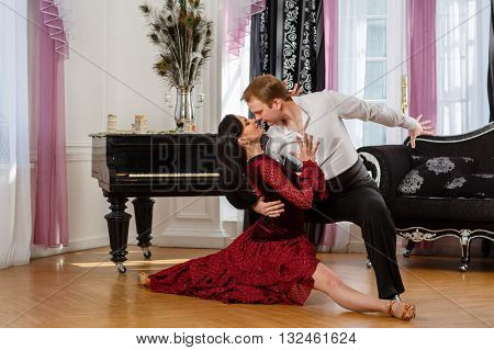 Dancing young couple in the room.