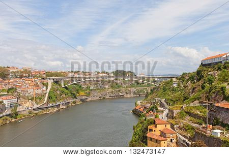 PORTO PORTUGAL - MAY 25 2016: Infante D. Henrique Bridge over Douro River in Porto city (UNESCO site) Portugal. Deck-stiffened arch bridge was erected in 2002