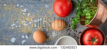Ingredients for baked eggs with tomatoes on the stone table wide screen