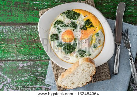 Florentine eggs with pureed spinach on the wooden table horizontal