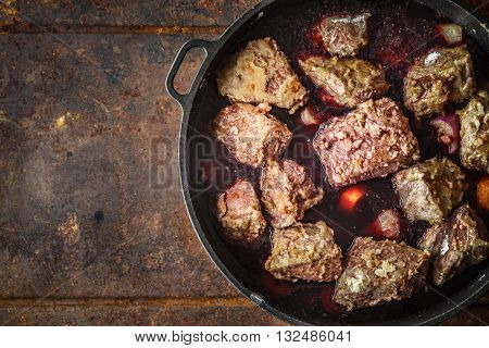 Boeuf Bourguignon in the pan on the metal background top view