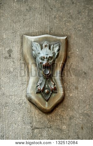 Antique vintage weathered bronze electric door bell with devil's face. Vertical orientation with copy space for text