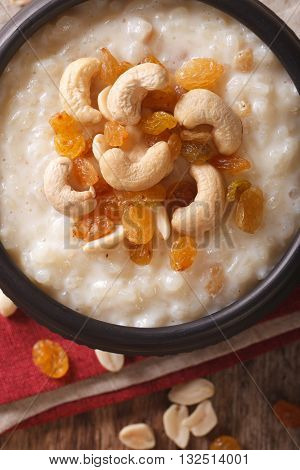 Sweet Rice Pudding With Nuts And Raisins In A Bowl Close-up. Vertical Top View