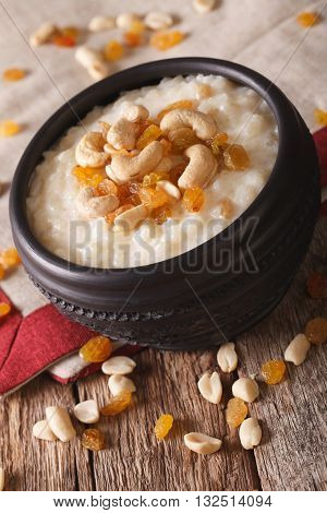 Sweet Rice Pudding With Nuts And Raisins In A Bowl Close-up. Vertical