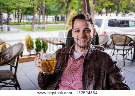 Portrait of handsome young man tasting a lager beer.