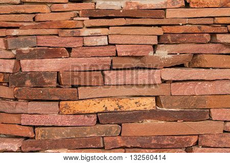 The wall of red stone. Decorative wall made of red stone.