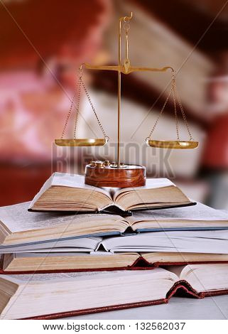 Justice scales with books on table in library
