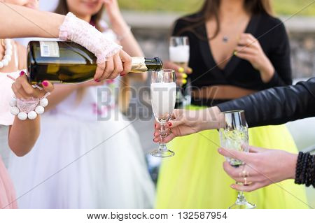 Group of girls celebrating a bachelorette party of bride. Celebration friends hen party concept - happy women with champagne glasses outdoors