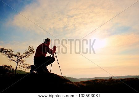 Nature Photographer With Tripod On Cliff And Thinking. Dreamy Fogy Valley Below