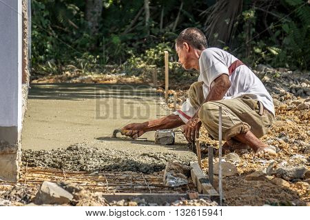 Labuan,Malaysia-April 7,2016:Undentified construction local worker doing concrete cement floor topping with float at construction Layang-Layang,Labuan,Malaysia.