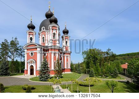 Orthodox Curchi monastery in Moldova with green trees and blue sky