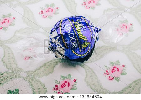KILCHBERG SWITZERLAND - MARCH 20 2014: Lindt Lindor chocolate truffle on a luxury silk background. Lindt is one one of the lastgest luxury chocolate and confectionery company worldwide