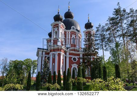 Orthodox Curchi monastery in Moldova with green trees and blue sky