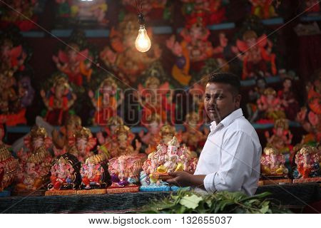 Pune India - September 16 2015: A man selling Lord Ganesh idols on the eve of Ganesh festival in India. The festival involves thousands of visitors from all over the world every year in the main celebration city - Pune.