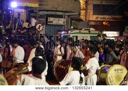Pune India - September 27 2015: People in India dancing on the streets on the beats of traditional percussion instrument dhol during a huge procession in the Ganesh festival