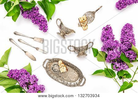 Lilac flowers. Coffee tea cake silber dishes. Flat lay floral background
