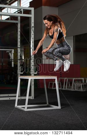 Young Fit Woman Doing Box Jumps In Gym
