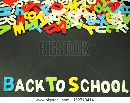 Colorful alphabet of back to school on wooden wood background with copy space at middle for text.