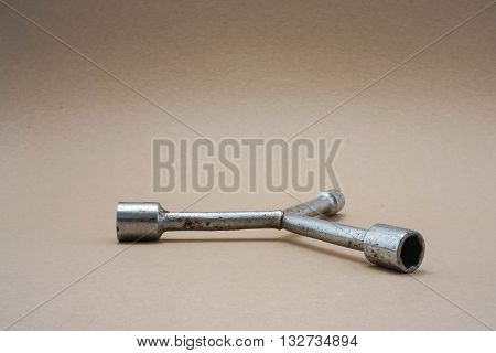 the 3-way lug wrench in brown background