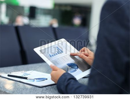 Business person analyzing financial statistics displayed on the tablet screen