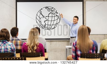 education, high school, teaching, geography and people concept - group of students and happy teacher with marker drawing earth globe on white board in classroom