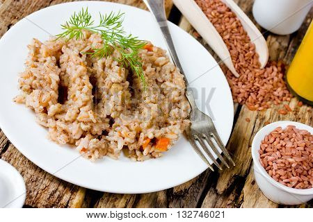 Pilaf of red rice devzira in a rustic style selective focus