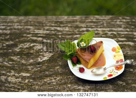 Flan - delicious creme dessert with caramel sauce.French creme caramel dessert or flan with strawberry and mint on the wooden background
