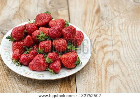 Plate of sweet red ripe handpicked strawberry.