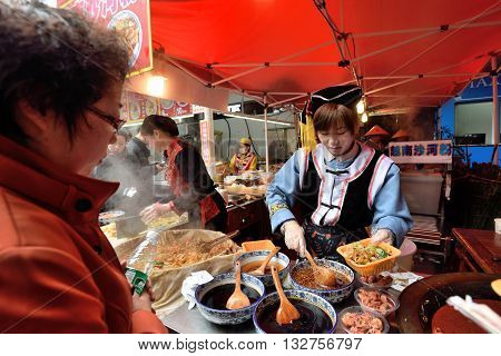 SHANGHAI CHINA - MARCH 19: Unidentified Chinese people trades traditional food on March 19 2016 in Shanghai China. Shanghai is the largest Chinese city by population.