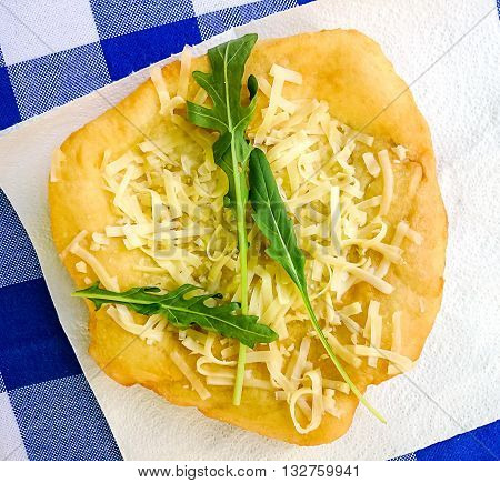 Warm Langos With Cheese, Garlic Cream And Arugula