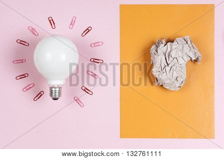 great idea concept with crumpled colorful paper and light bulb on light background. Creative brainstorm concept business idea. female hand holding light bulb. Copy space for text.