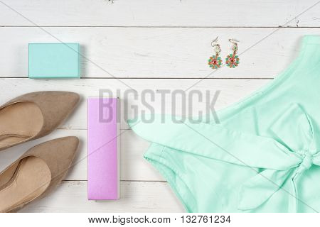 Women clothing set and accessories on a rustic wooden background.Top view Copy space for text.