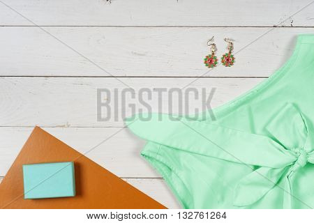 Women clothing set and accessories on a rustic wooden background.Top view