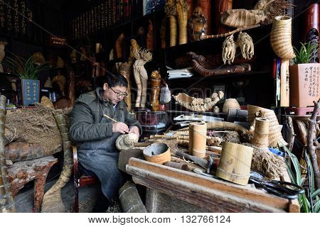 WUZHEN CHINA - MARCH 24: Unidentified chinese craftsman making traditional souvenirs on March 24 2016 in Wuzhen China. Wuzhen is a historic scenic town located in northern Zhejiang Province China