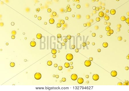 Yellow oil bubbles folat over a blurred background