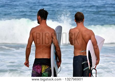 Amateur surfers are waiting for waves on the beach