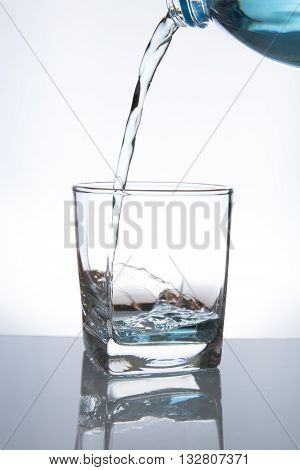 Concept of drinking. Pouring water from into glass